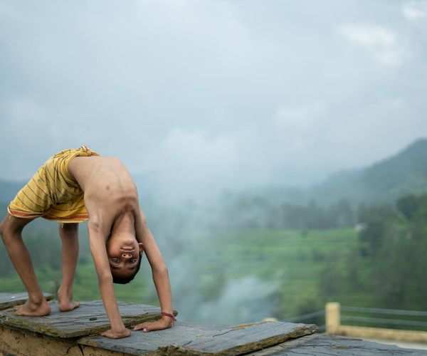 A person sitting in a meditative pose outdoors with a serene natural background.